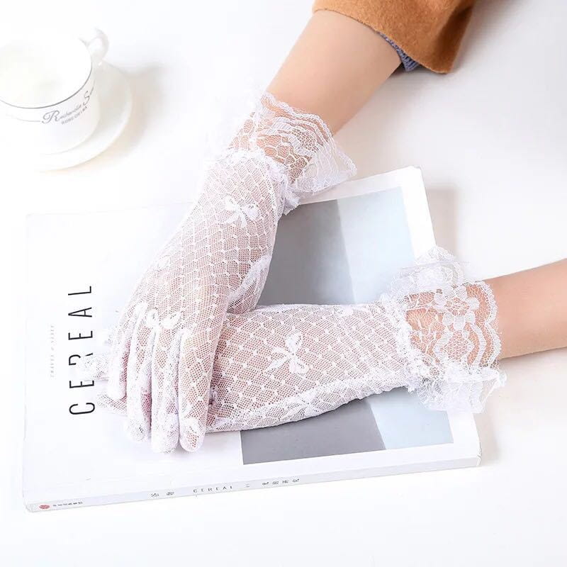 White lace gloves with delicate floral patterns and ruffled cuffs complement elegant black floral lace ruffled bow gloves.