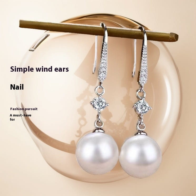 Elegant silver drop earrings featuring a pave diamond accent above a lustrous white pearl in a sophisticated design.