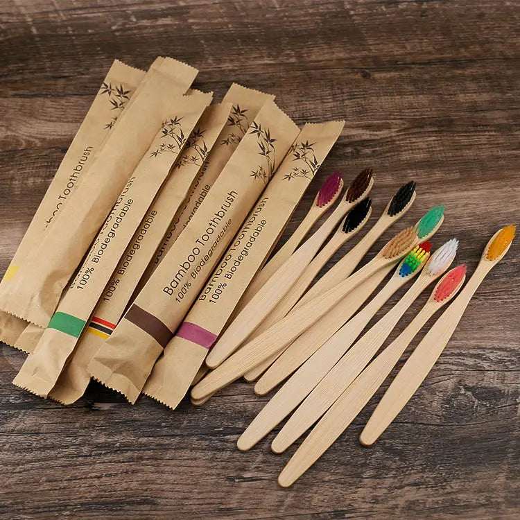 Un conjunto de cepillos de dientes de bambú respetuosos con el medio ambiente con cerdas suaves en varios colores, incluidos rojo, negro, verde y patrones arcoíris.