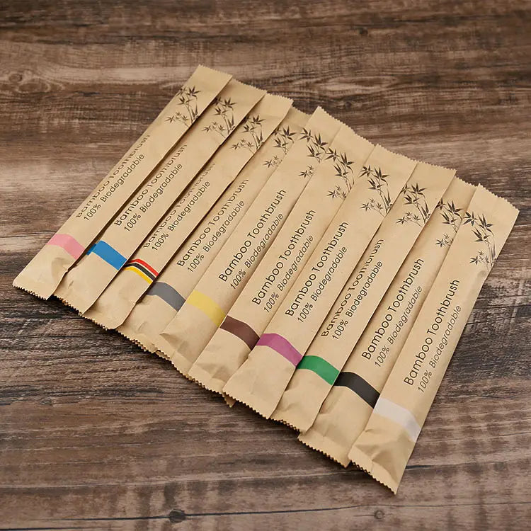 Juego de cepillos de dientes de bambú de 10 unidades con cerdas suaves, respetuoso con el medio ambiente, con envoltorios de papel color beige con franjas de colores y diseños de hojas de bambú.