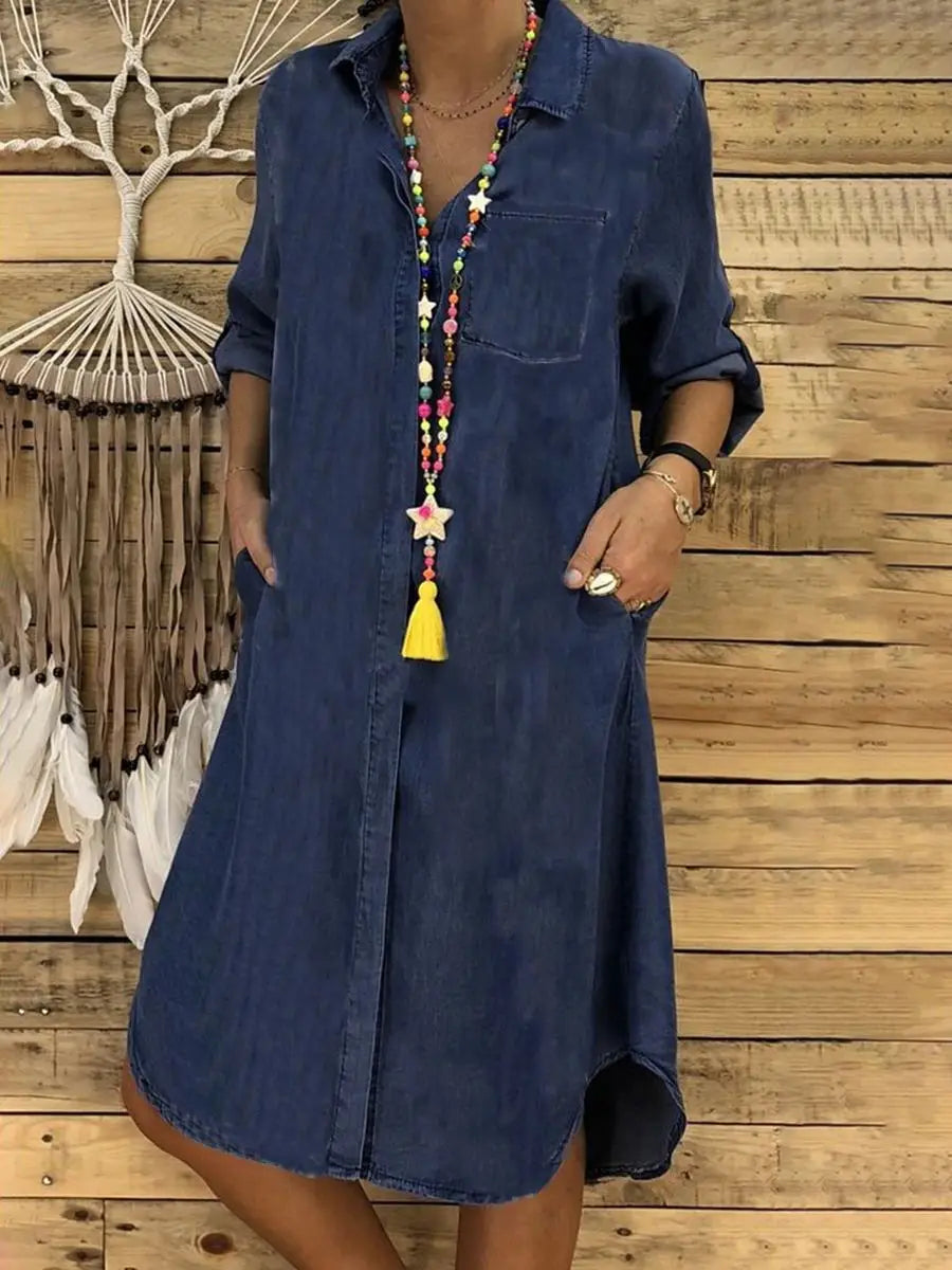 woman wearing a blue denim shirt dress with rolled-up sleeves and front button closure
