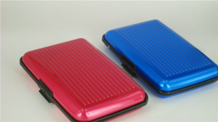 rfid blocking aluminum alloy ribbed card holder cases in red and blue metallic colors with textured surfaces.