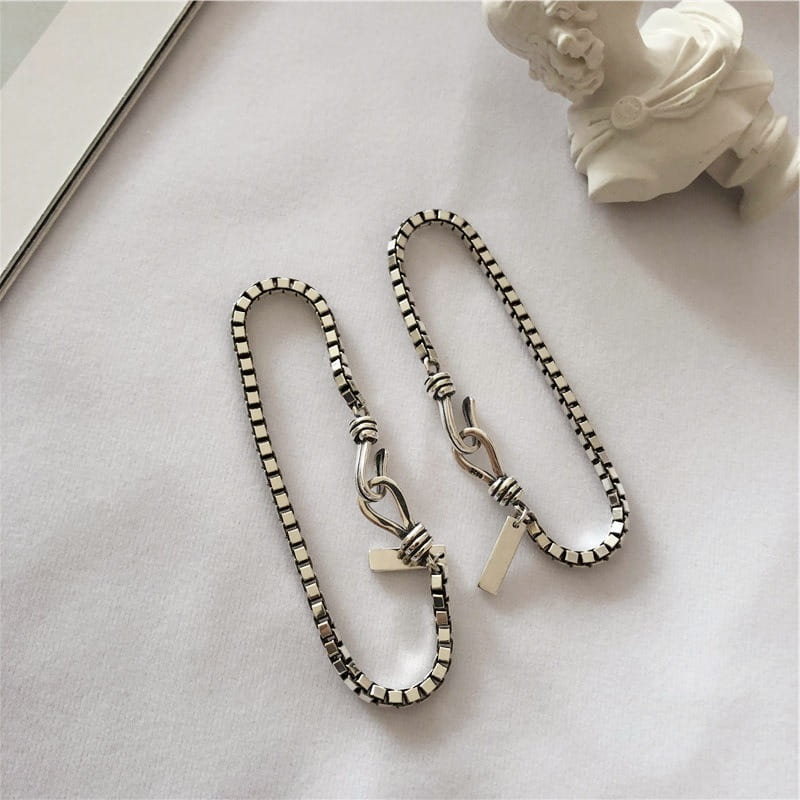 Vintage silver box chain cross bracelet featuring silver-toned wallet chains with a textured interlocking design and minimalist toggle clasps.