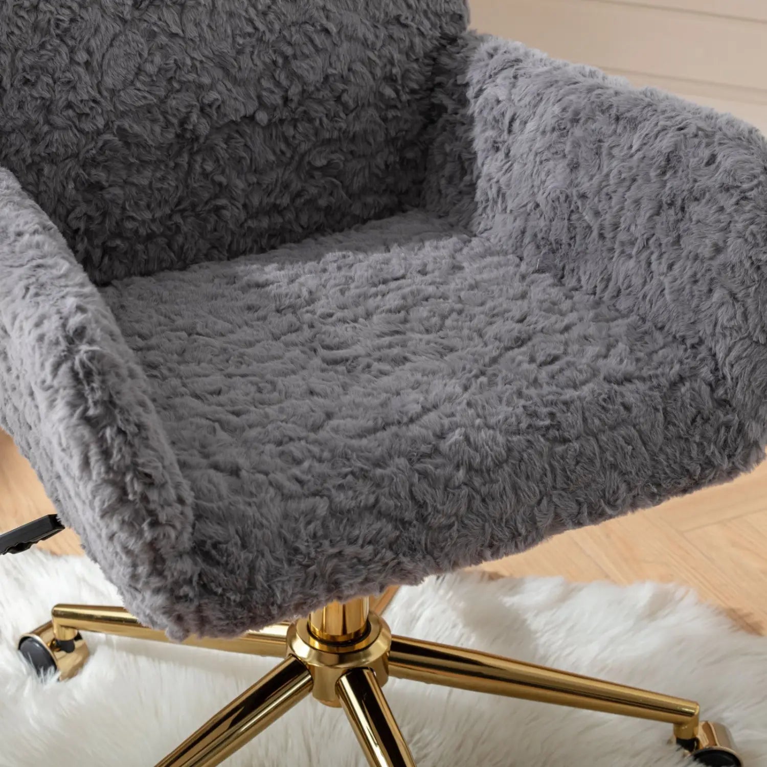 Chaise de bureau en fausse fourrure gris clair, avec une housse de fauteuil duveteuse gris clair rembourrée et une surface texturée, et une base en métal à ton doré.