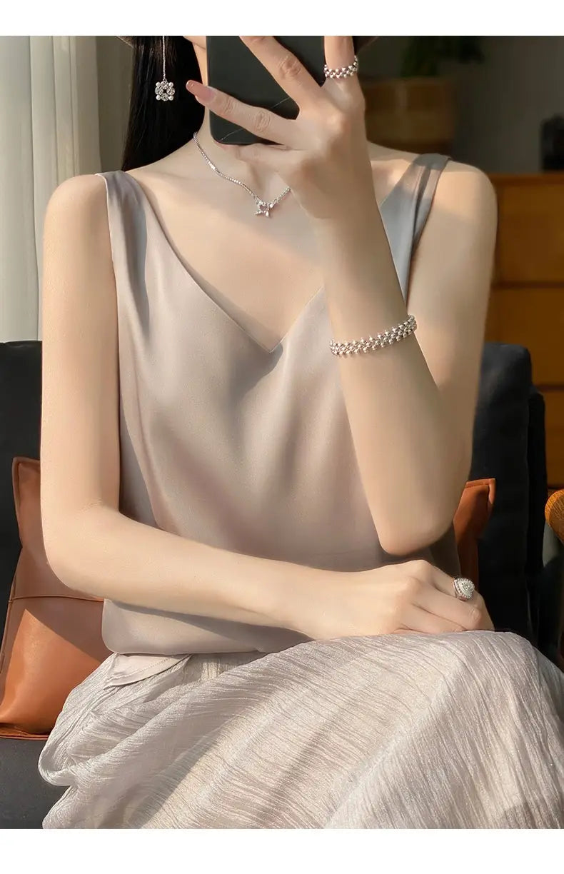 A soft light gray silky satin v-neck camisole top with a sleeveless design and flattering neckline.