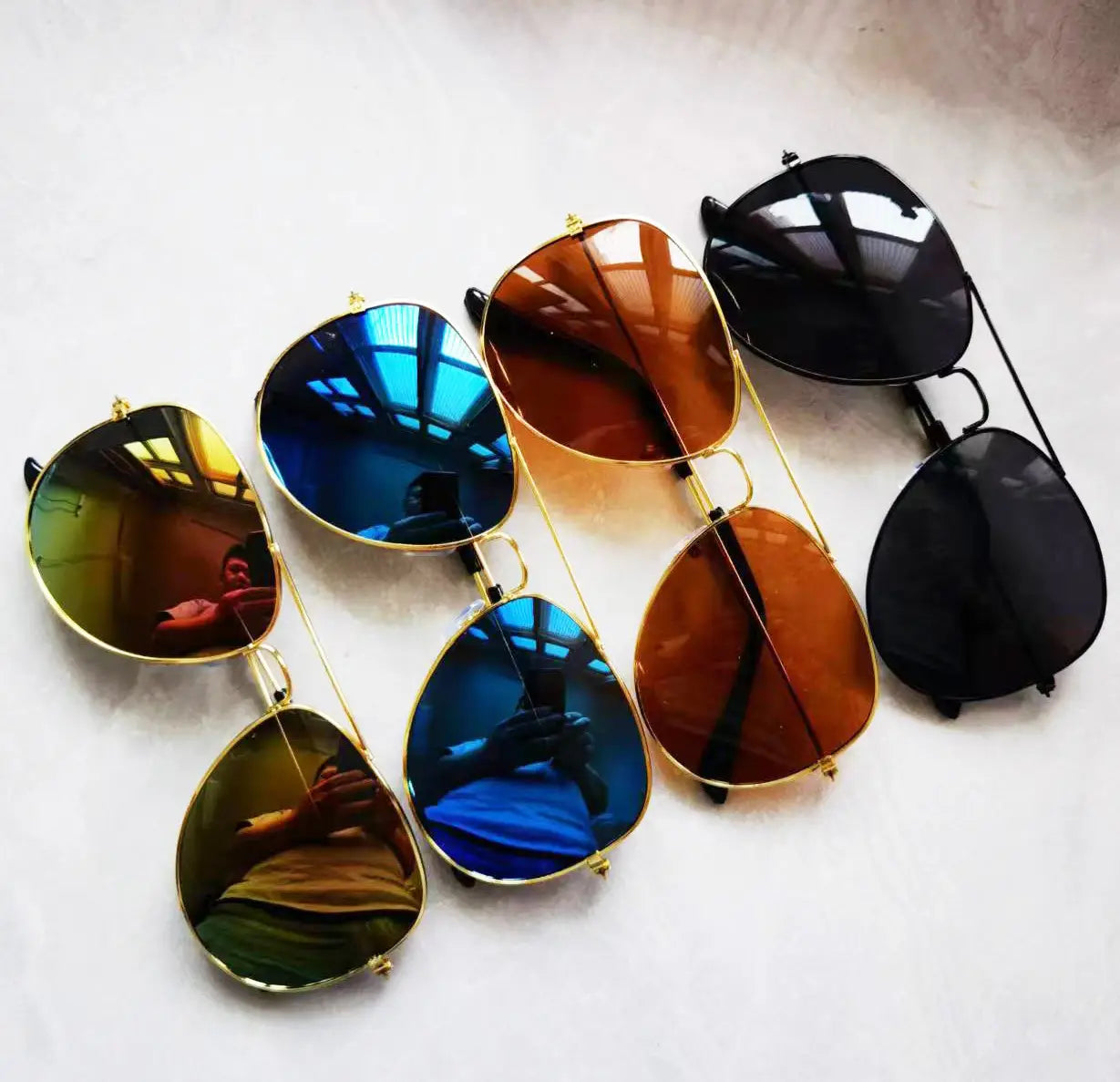 Set of classic gold rimmed aviator uv protection sunglasses with reflective lenses in gold, blue, and brown frames.