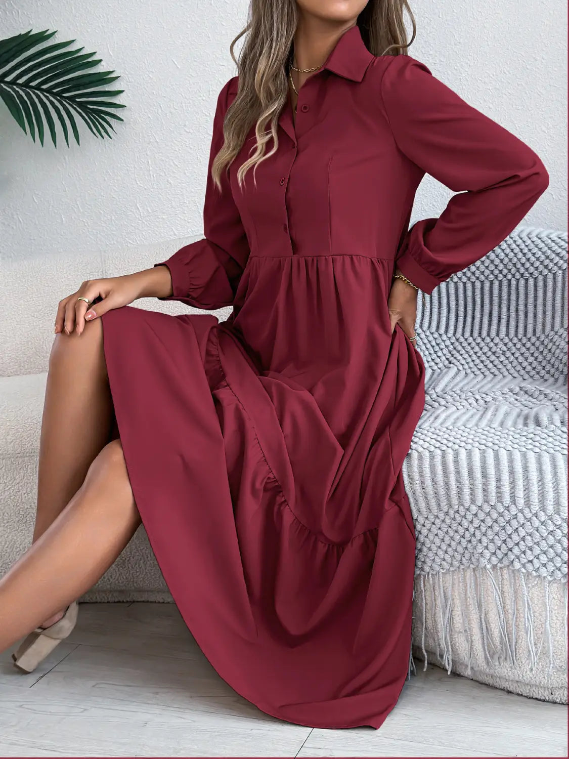 A flowing maroon long sleeve tiered button down midi dress with a button up collar designed for women.