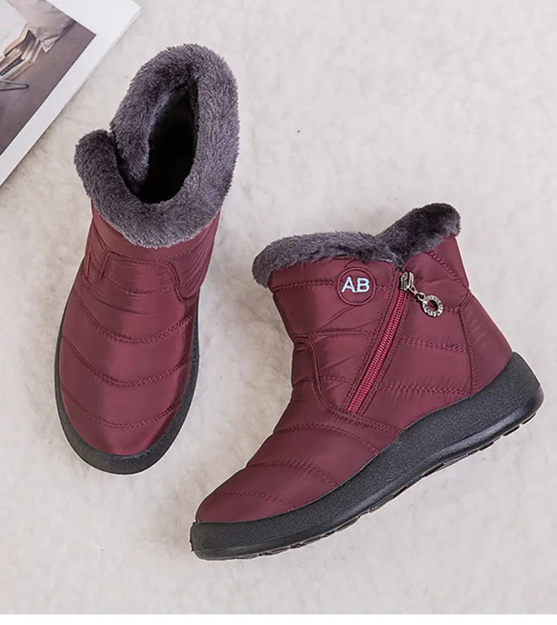 Bottes d’hiver imperméables en neige bordeaux matelassées, avec doublure en fausse fourrure grise et semelles en caoutchouc noires, conçues pour protéger la cheville avec un confort moelleux.