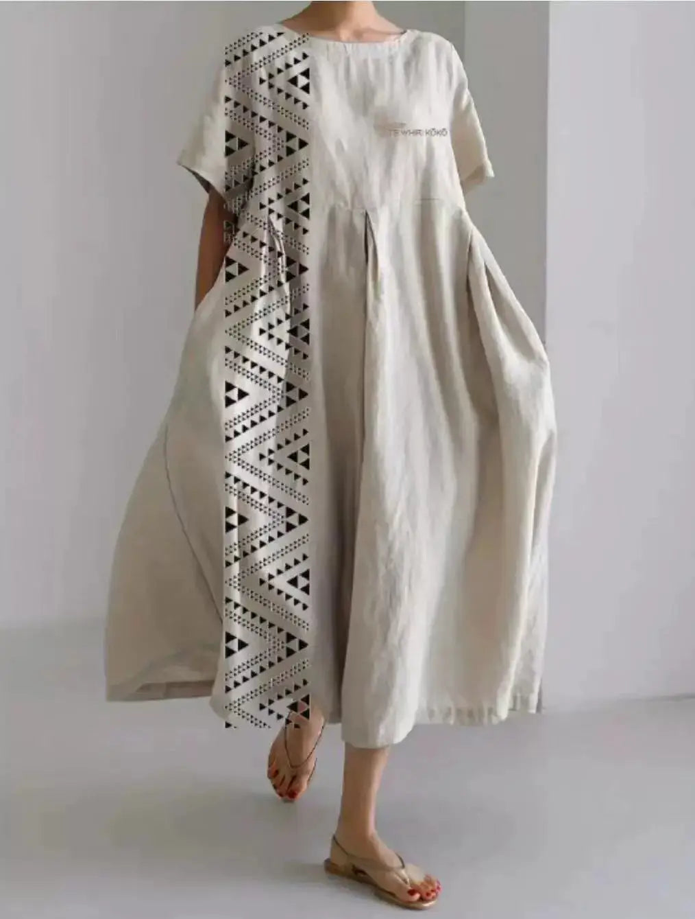 Artistic printed loose linen maxi dress in off-white featuring a bold black geometric pattern along one side and subtle embroidery on the chest.
