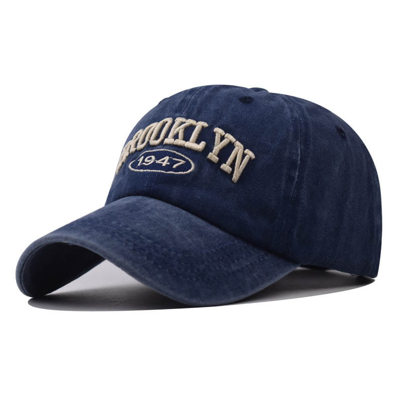 Navy blue cotton baseball hat with Brooklyn 1947 embroidered in beige thread on the front.