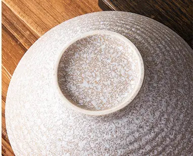 Eine graue japanische Keramikschale mit einer strukturierten craquelierten Glasur und konzentrischen Rillen, ideal für Sets mit rustikal gesprenkeltem Tischgeschirr.