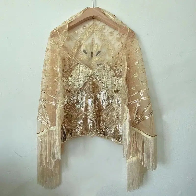Ein zartes beiges Spitzen-Pailletten-gesticktes Mesh-Camisole-Top mit aufwendigen goldfarbenen Paillettenmustern und langen Fransenverzierungen.