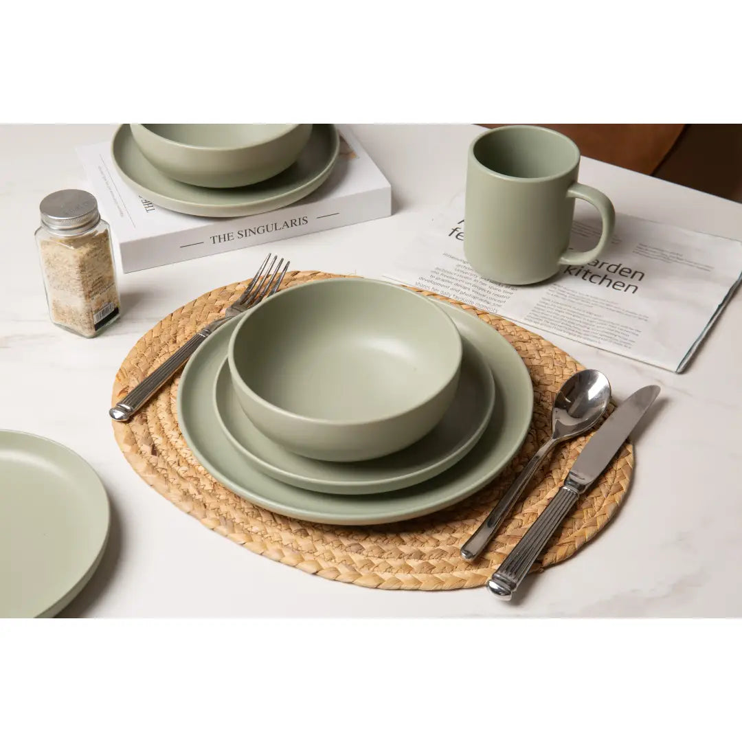 ensemble de vaisselle en grès cérame vert sauge, 12 pièces, avec des assiettes, des bols et une tasse en céramique vert menthe, conçu pour trois personnes.
