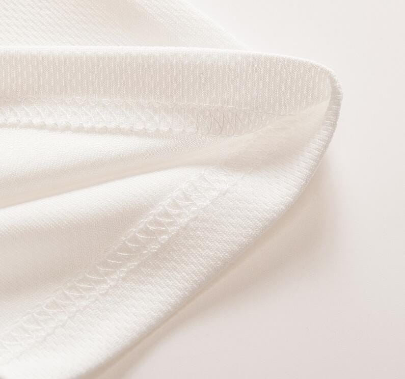 Ein weicher weißer Stoff mit glatter Struktur und feiner Ziersteppung entlang der Kante eines Herren-Geometric-Shortsleeve-Hemds mit Knopfleiste.