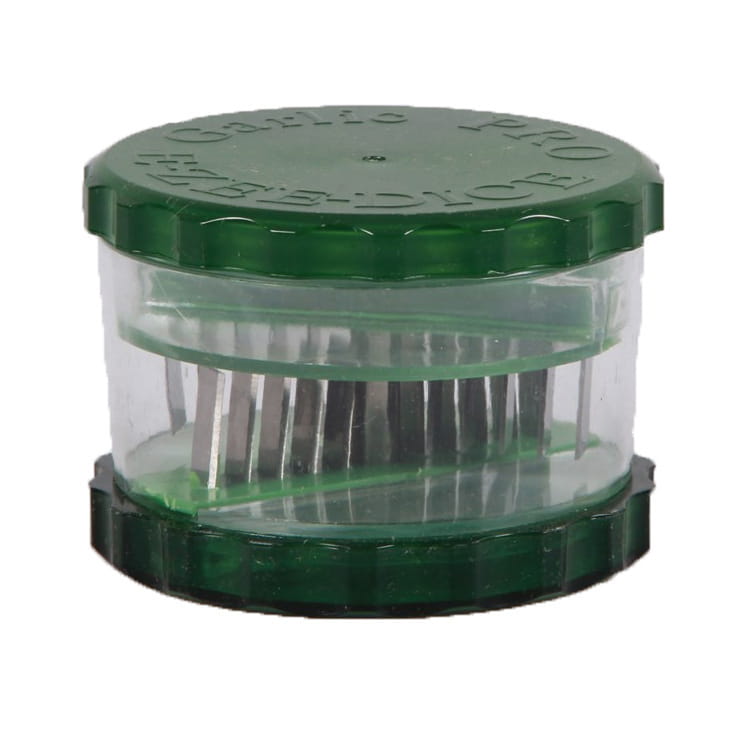 Garlic Pro manual grinder and peeler kitchen tool in green plastic with clear central chamber and serrated edges for efficient garlic pressing.