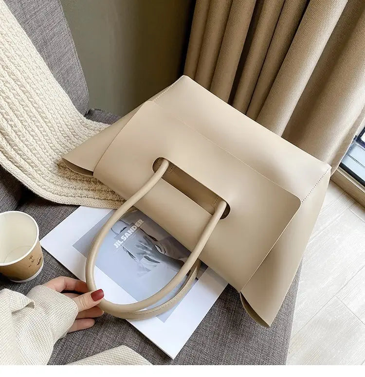 Beige leather vintage structured tote bag with a rectangular shape and matching top handles.