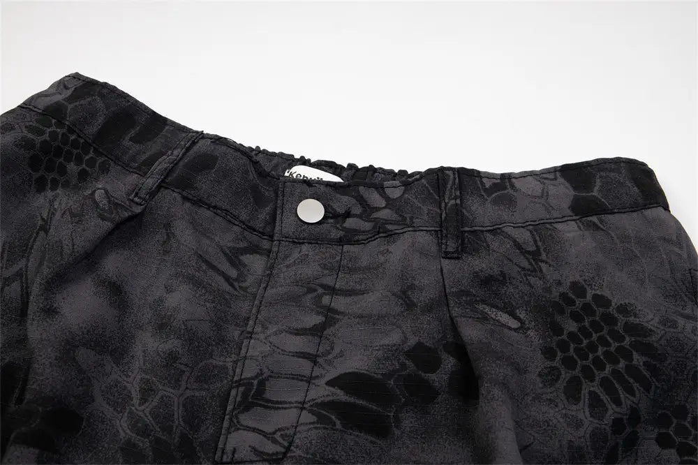 Black camouflage cargo pants wide leg tactical trousers featuring a subtle dark-toned snake-scale pattern and reinforced stitching.