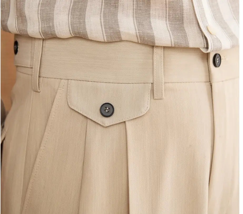 Beige maßgeschneiderte gerade Beinschlag-Hosen für Herren mit Knopfverschluss an der Vorderseite und dunklen Knöpfen.