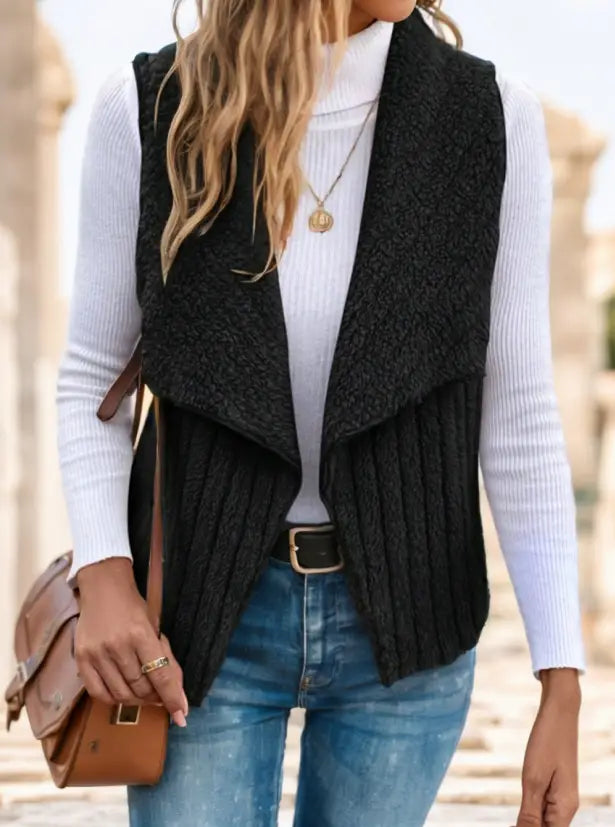 Schwarze gerippte Strickweste mit Wasserfallkragen, drapiertem Vorderteil und asymmetrischem Saum, entworfen als Oberbekleidung.