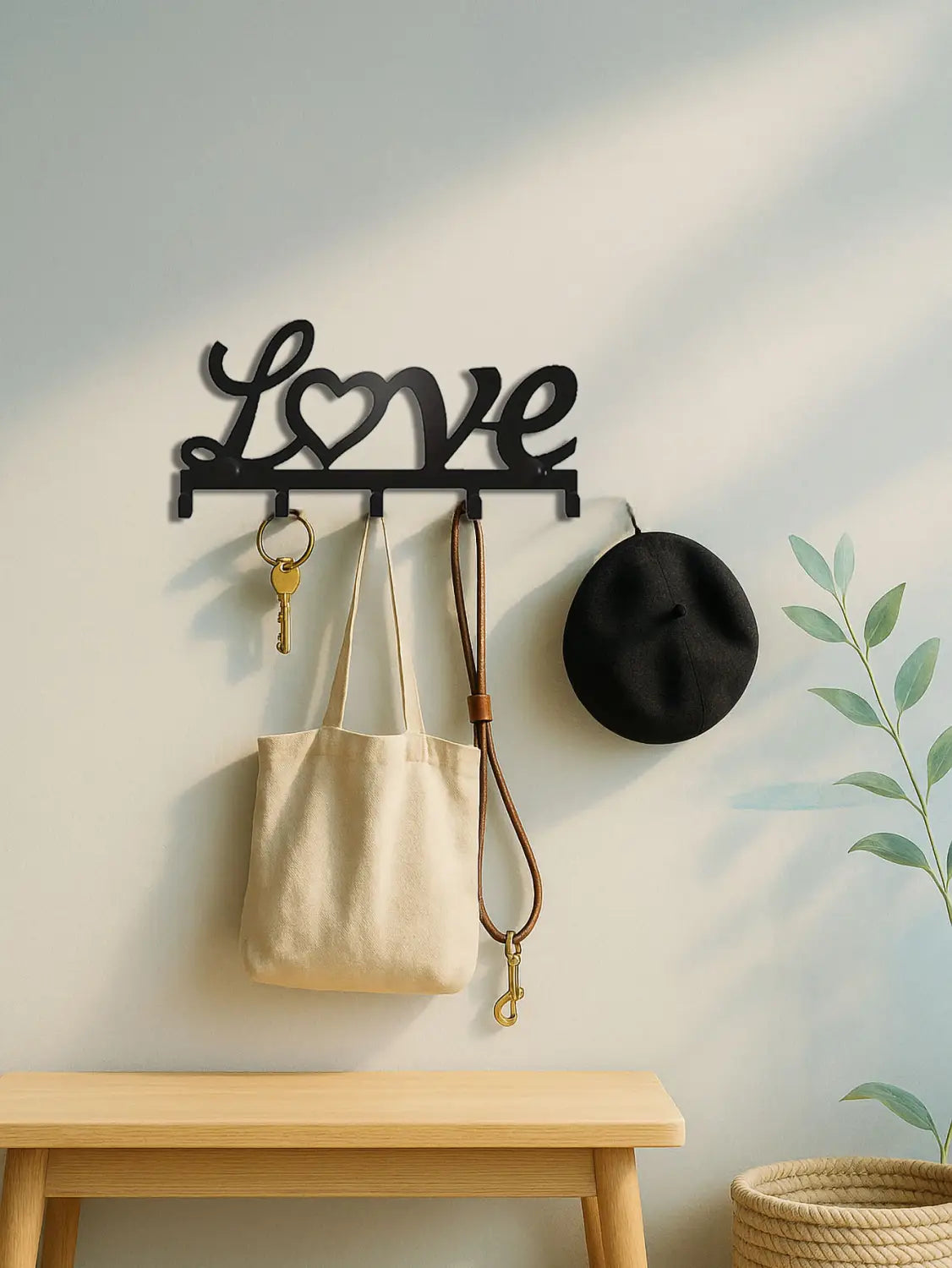 Black metal wall hook rack shaped like the word love with a heart key holder and five pegs in a black metal finish.
