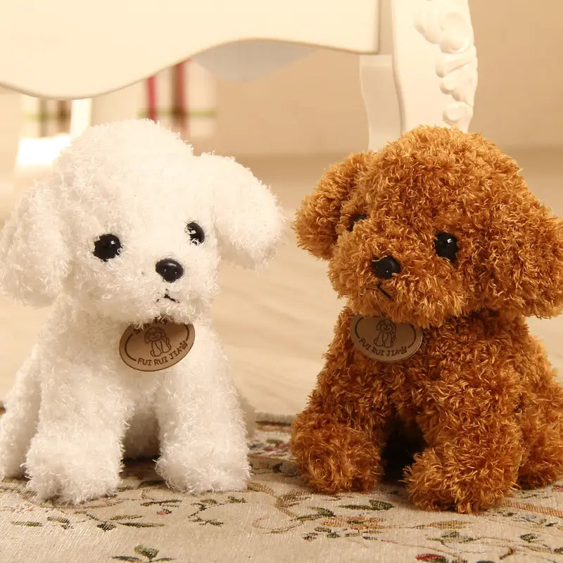 Dos peluches de perro oso de peluche con diseño de caniche esponjoso en blanco y marrón, con ojos de botón negros y pequeñas etiquetas circulares alrededor del cuello.