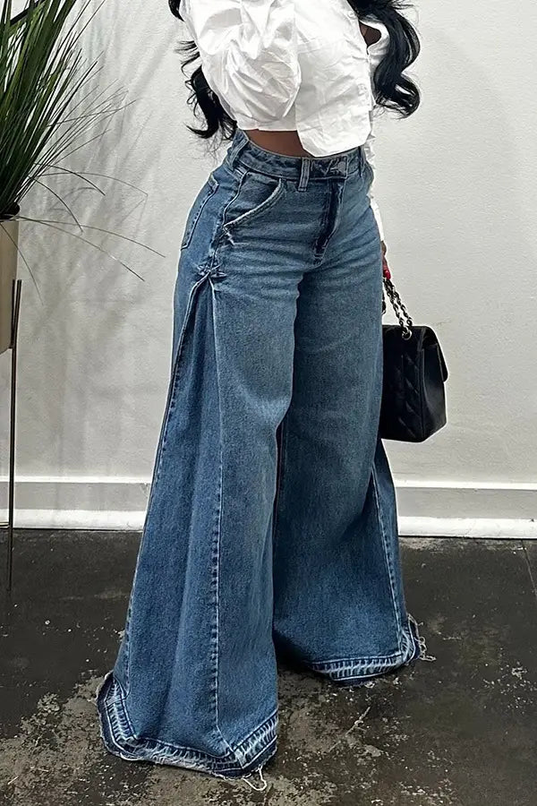 Jeans en denim à taille haute, jambe large, délavage bleu moyen, avec ourlets à franges et finitions de fente latérale.