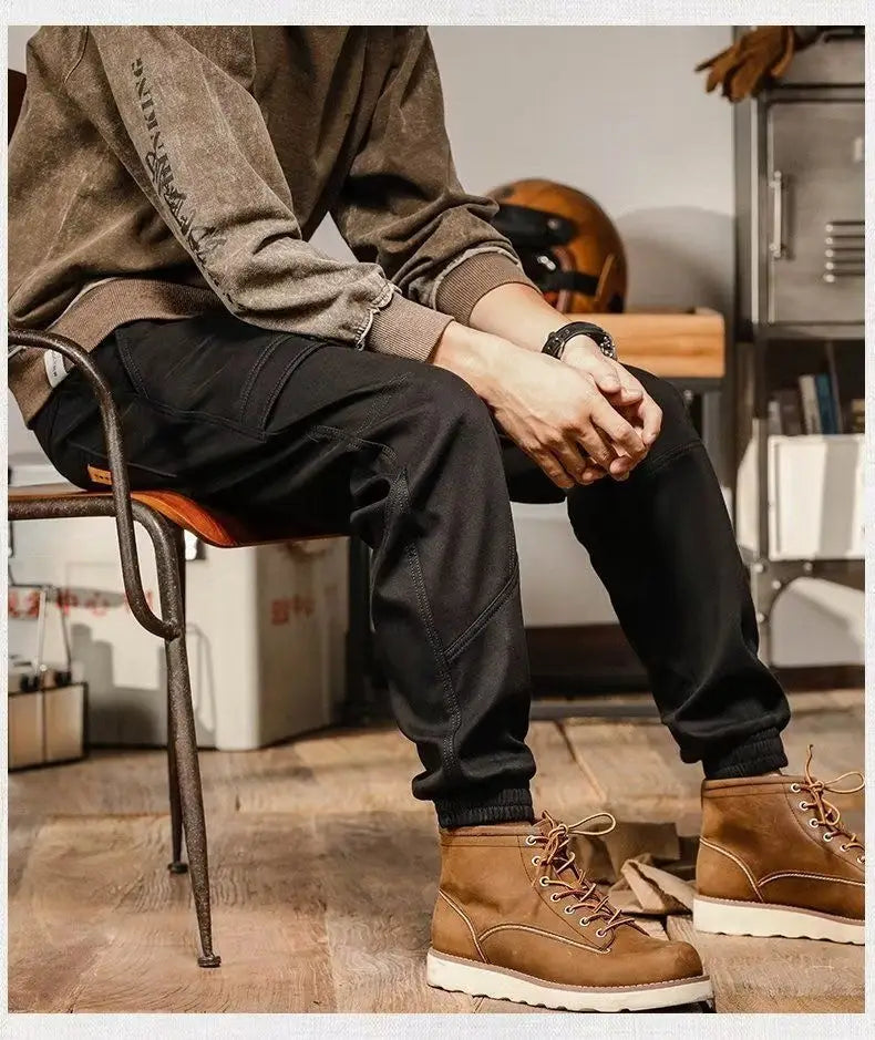 Bottes de travail en cuir brun avec des semelles blanches et des lacets tan, associées à des pantalons cargo pour hommes à coupe ample, style décontracté et vêtement de travail.