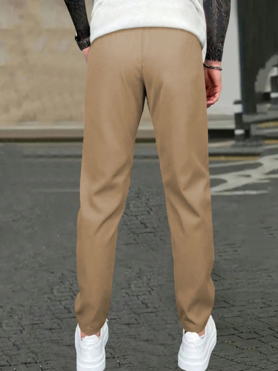 Beige slim fit tapered jogger pants with drawstring featuring subtle creases and made from chino material.