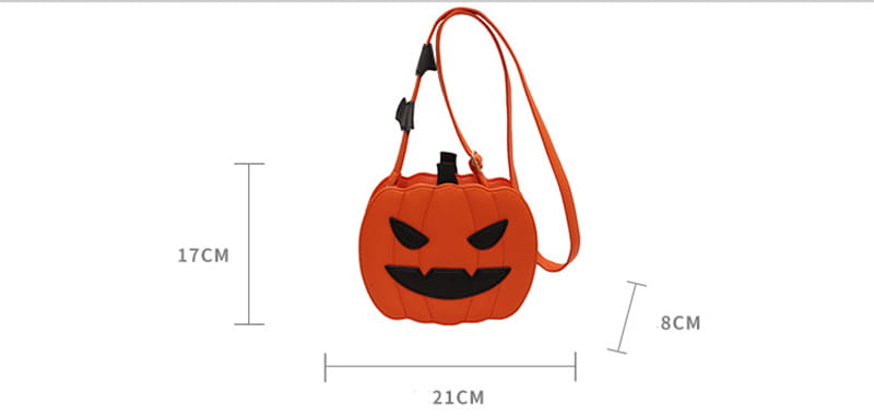 Orange pumpkin-shaped crossbody bag with black facial features, matching orange strap, and detachable bat charm.