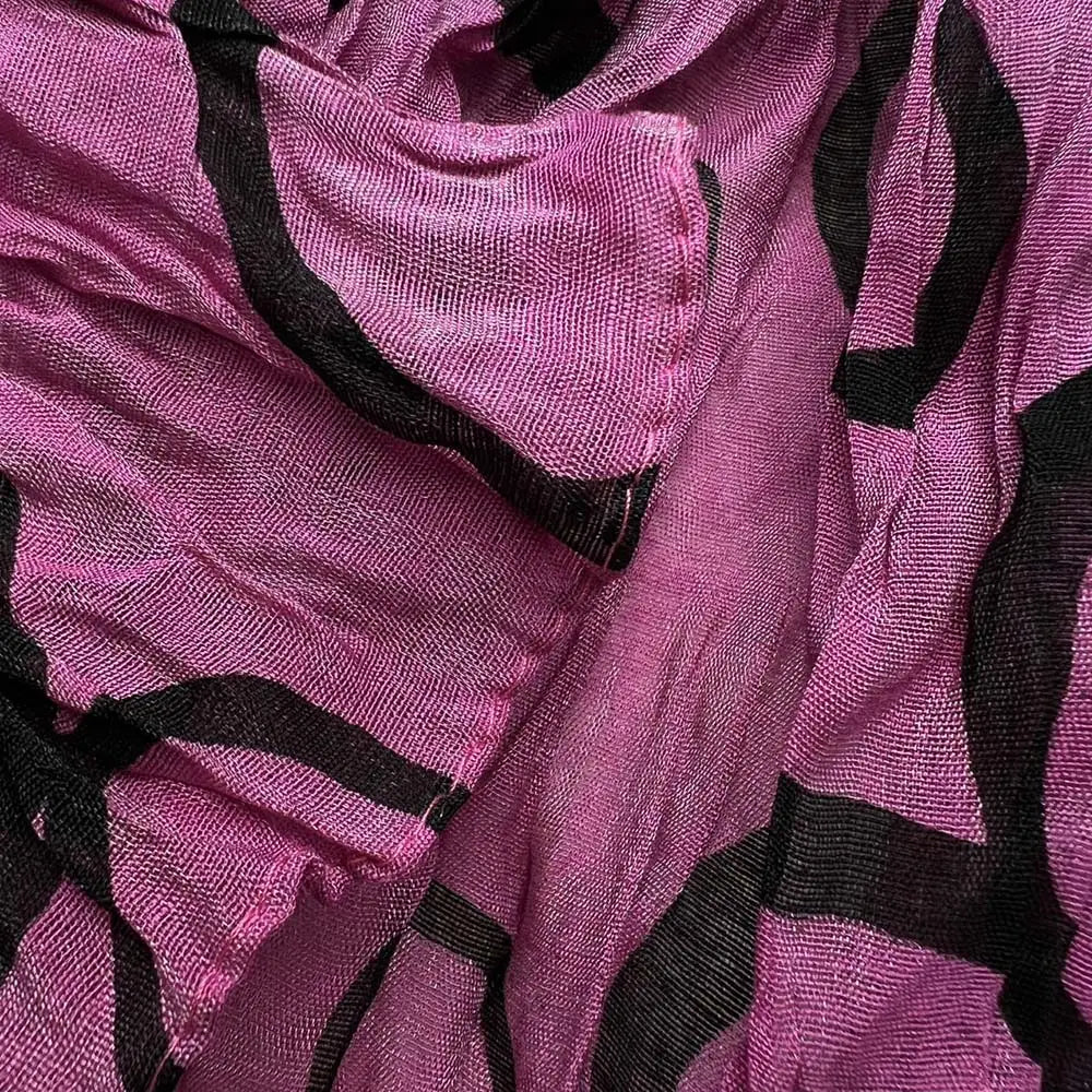 Un foulard en polyester froncé fuchsia doux, à texture transparente, avec des bandes géométriques noires audacieuses.