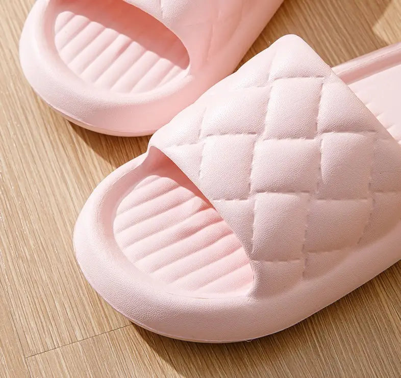 pink quilted slide sandals with a soft cushioned sole and textured grip designed for lightweight non slip home use