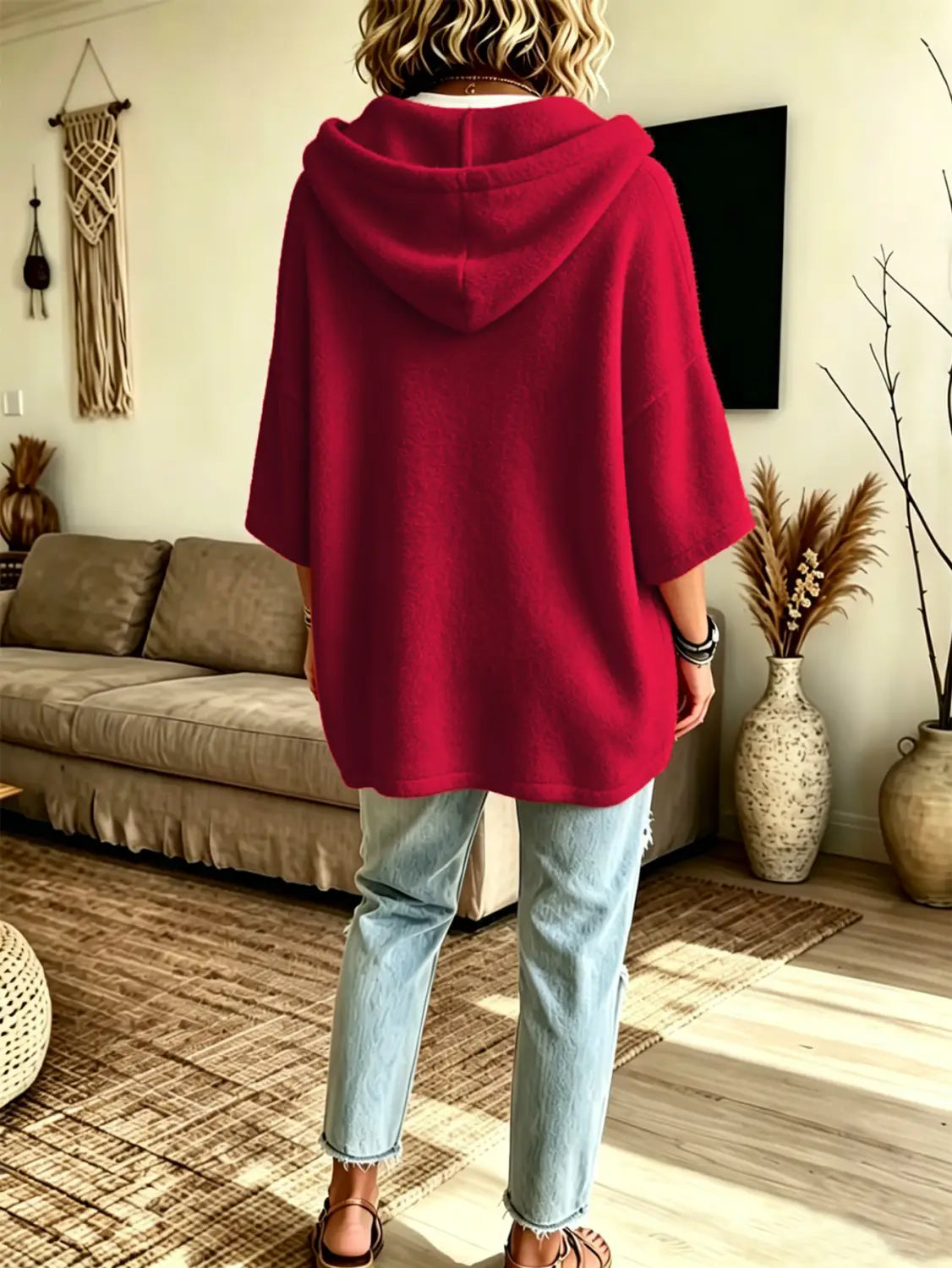 A cozy vibrant red oversized fleece hooded poncho with a soft loose-fitting silhouette and three-quarter sleeves.