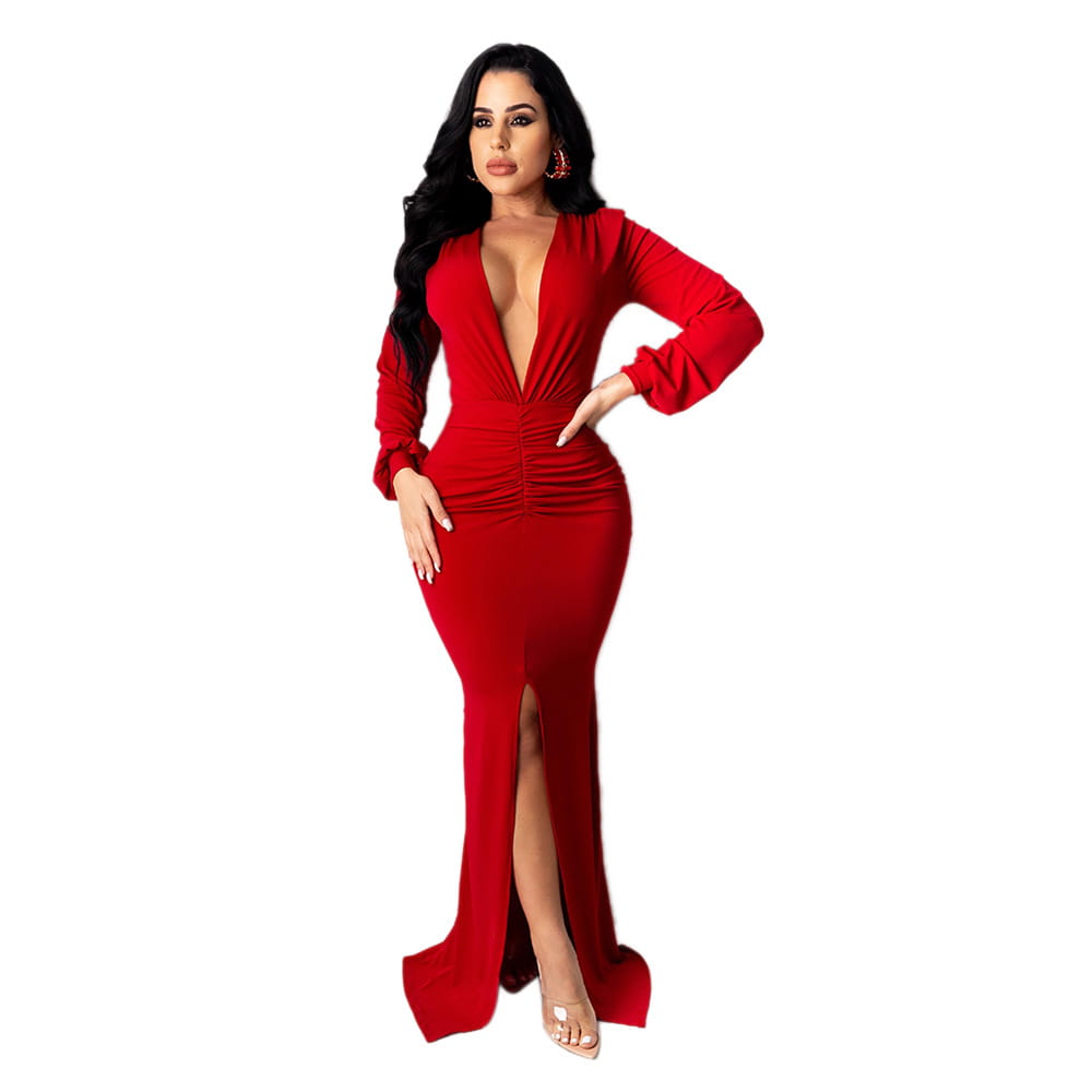 A striking red velvet v neck evening dress with long sleeves, a plunging neckline, and a high slit.