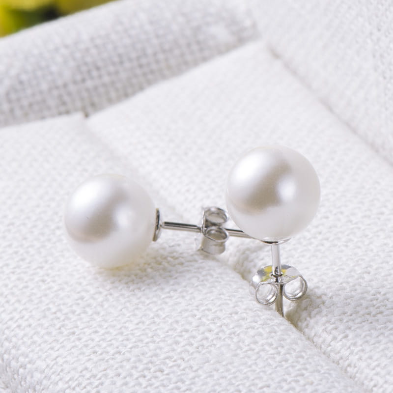 A pair of sterling silver freshwater pearl stud earrings featuring elegant white pearls with sleek silver metal posts and butterfly backings.