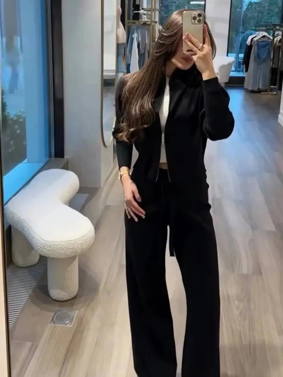Black tailored knit zip up cardigan and wide leg pant set featuring a high-neck top and matching wide-leg trousers.