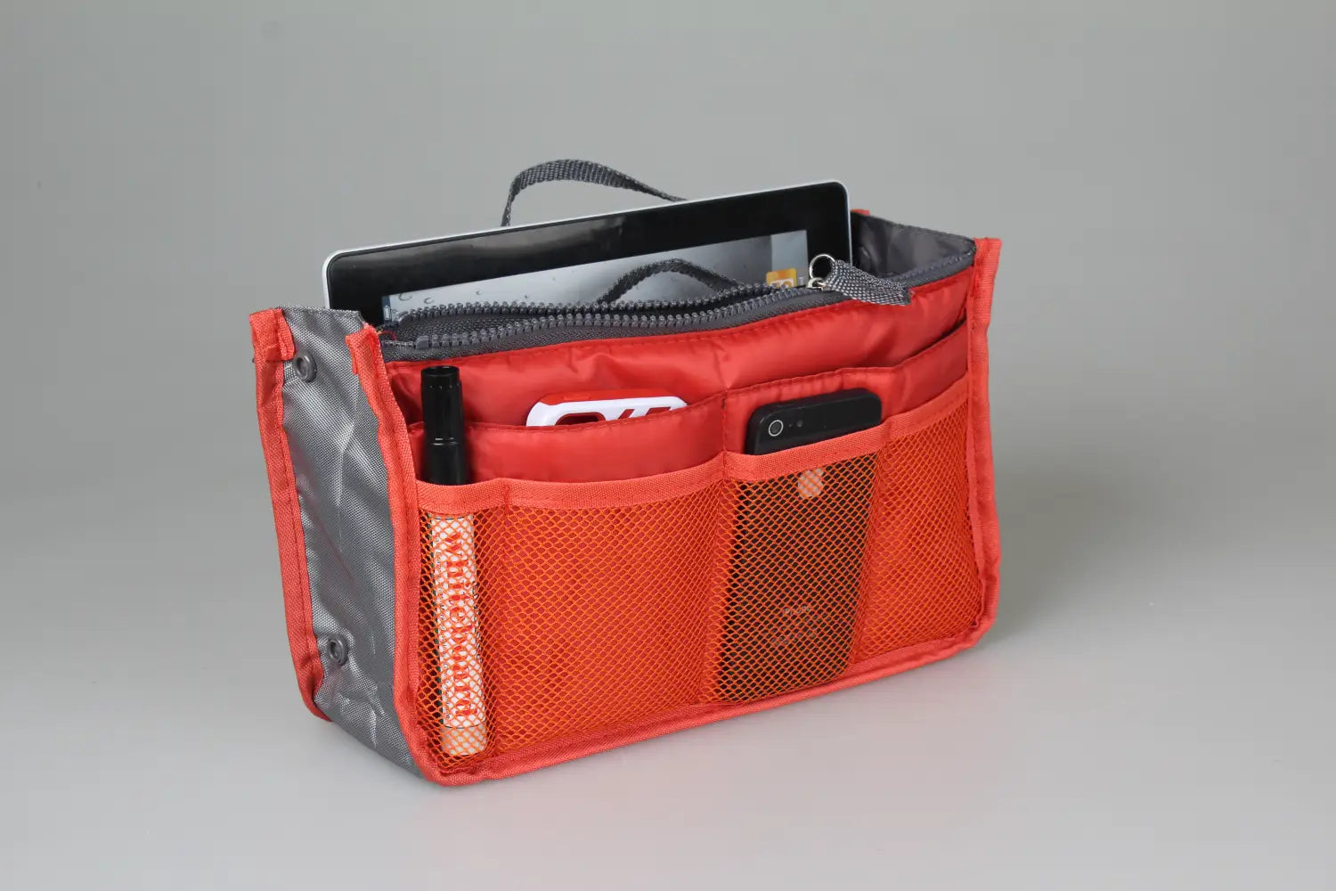 Red and gray mesh multi-pocket nylon handbag organizer with dual zippers featuring multiple compartments including a zippered main section and side pockets for phones and tablets.