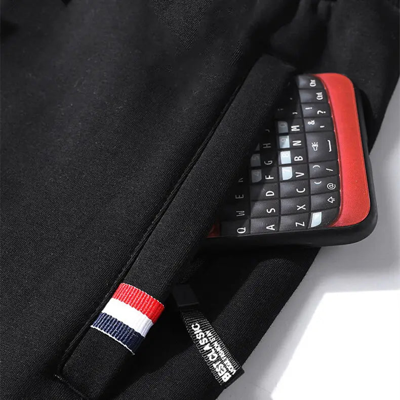 black backpack featuring a red white and blue striped fabric tab shown alongside men fleece lined joggers straight leg cotton sweatpants.