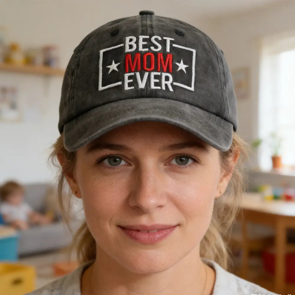 Gorra de béisbol de algodón desgastado gris oscuro con bordado de la mejor mamá de todas en hilo blanco y rojo entre dos estrellas.