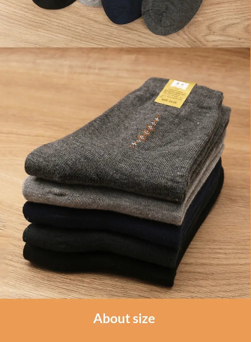 A stack of neatly folded men mid calf crew socks 5 pack in gray and black with a subtle textured pattern on the top pair.
