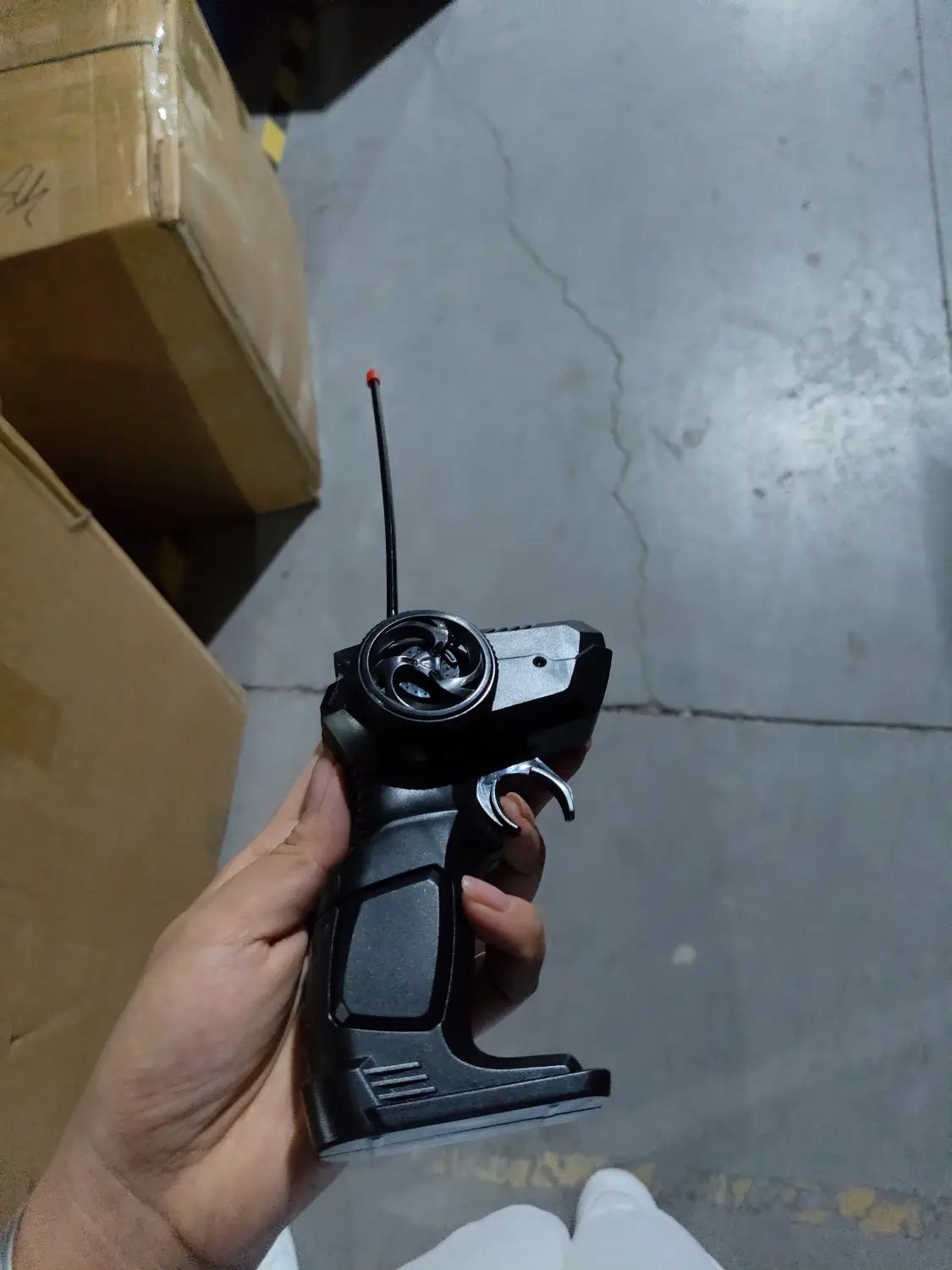 Control remoto plástico negro con antena roja y gatillo plateado para el juguete de camioneta teledirigida RC todoterreno 4WD de alta velocidad.