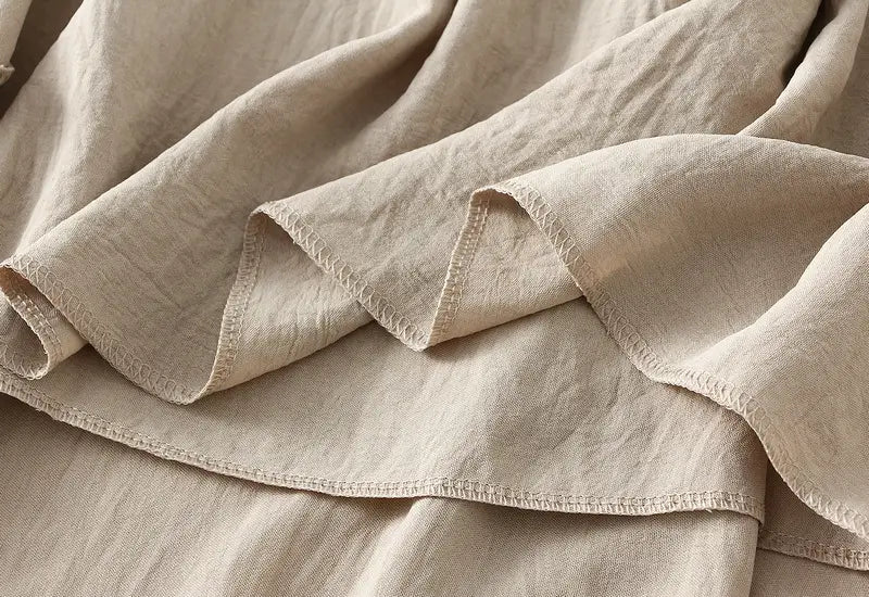 Beige linen pleated wide flare maxi skirt with a soft textured weave and neatly finished edges.