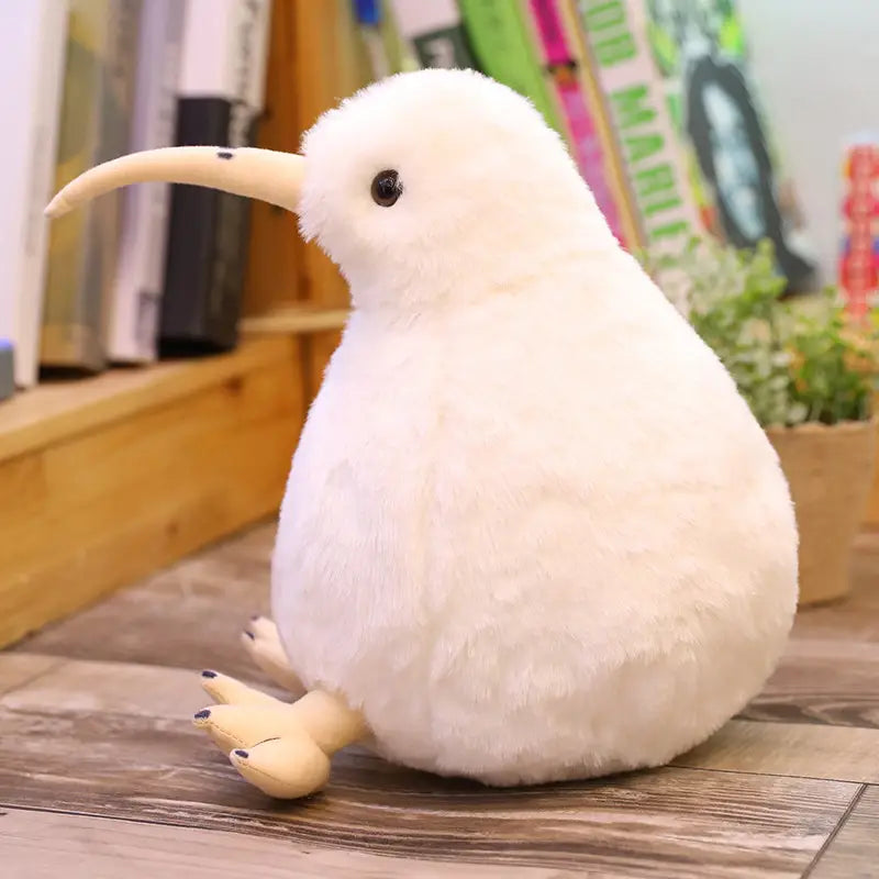 長く湾曲したくちばしと黒い目を特徴とする、白いキウイバードのふわふわのぬいぐるみキーチェーン。