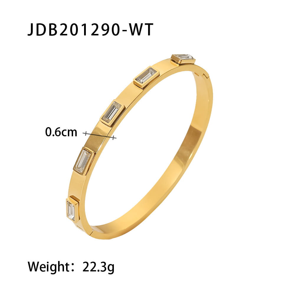 Gold plated stainless steel bangle bracelet in a gold tone featuring five rectangular clear zirconia gemstones set along its sleek polished surface.