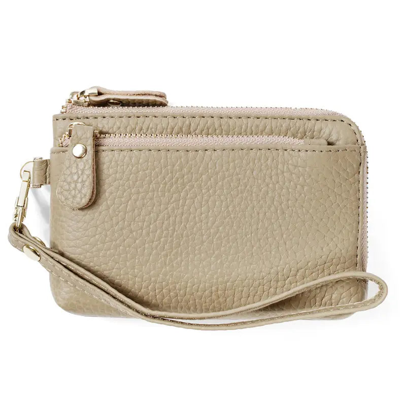 Beige textured leather wristlet wallet with dual zippers and gold hardware for secure and stylish organization.