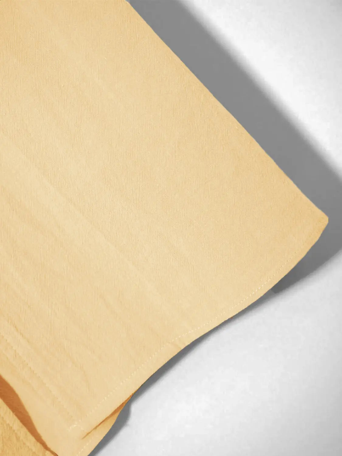 une chemise en lin boutonnée ample et décontractée pour homme, dans un tissu jaune pâle doux, avec une légère structure tissée