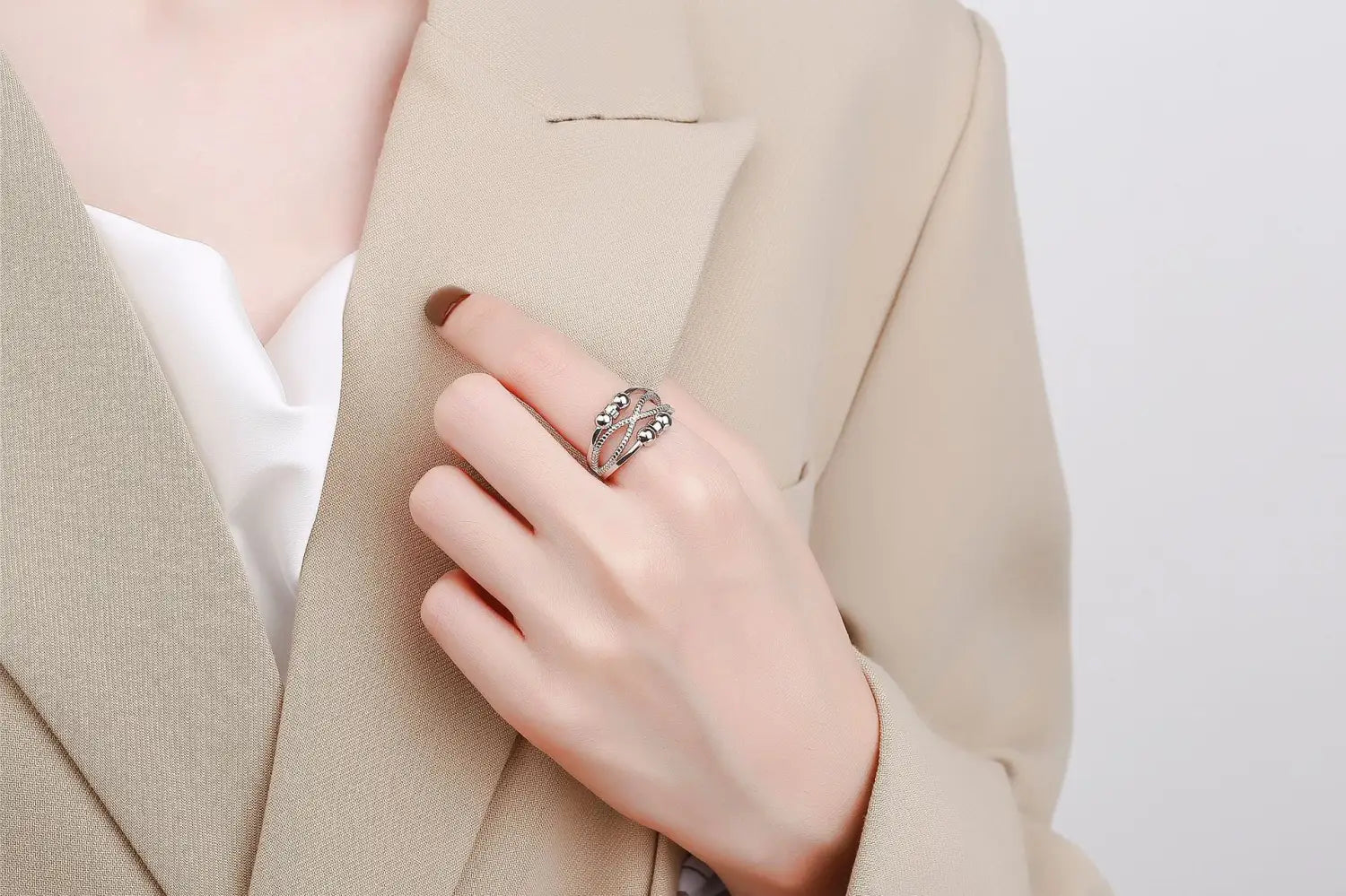 Silver interwoven anxiety relief adjustable ring featuring intricate swirling filigree design with embedded small stones.