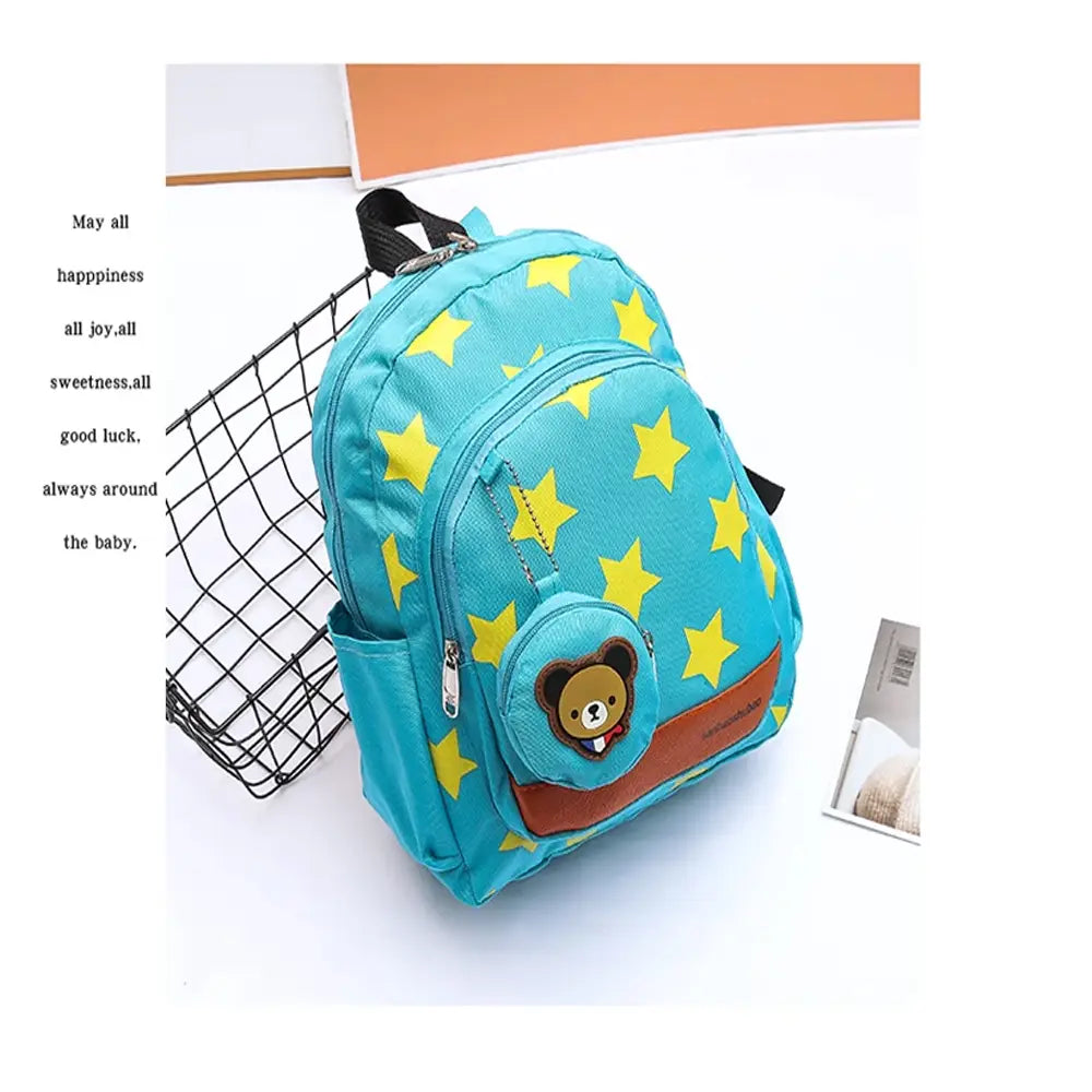A turquoise star print soccer backpack for children featuring yellow stars and a brown bear face patch with an attached bear coin purse on the front pocket.