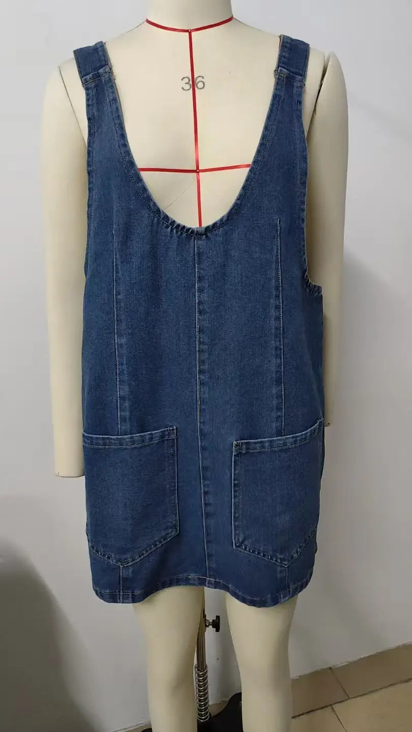 vestido peto de mezclilla azul de longitud media con ribete de encaje que presenta dos bolsillos delanteros y tirantes de hombro ajustables.