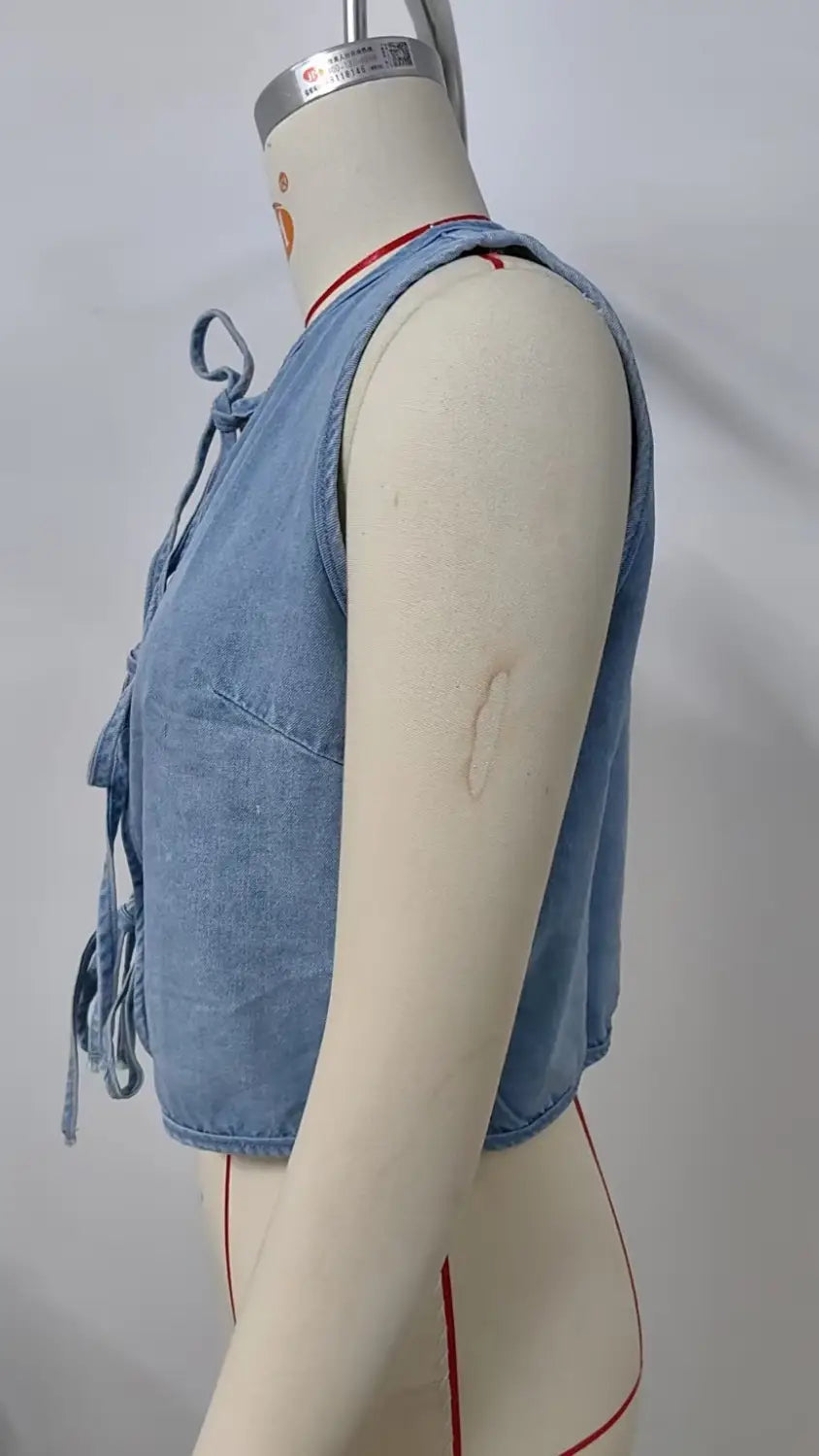 Light blue denim sleeveless crop top with a front bow tie detail from the Y2k collection.