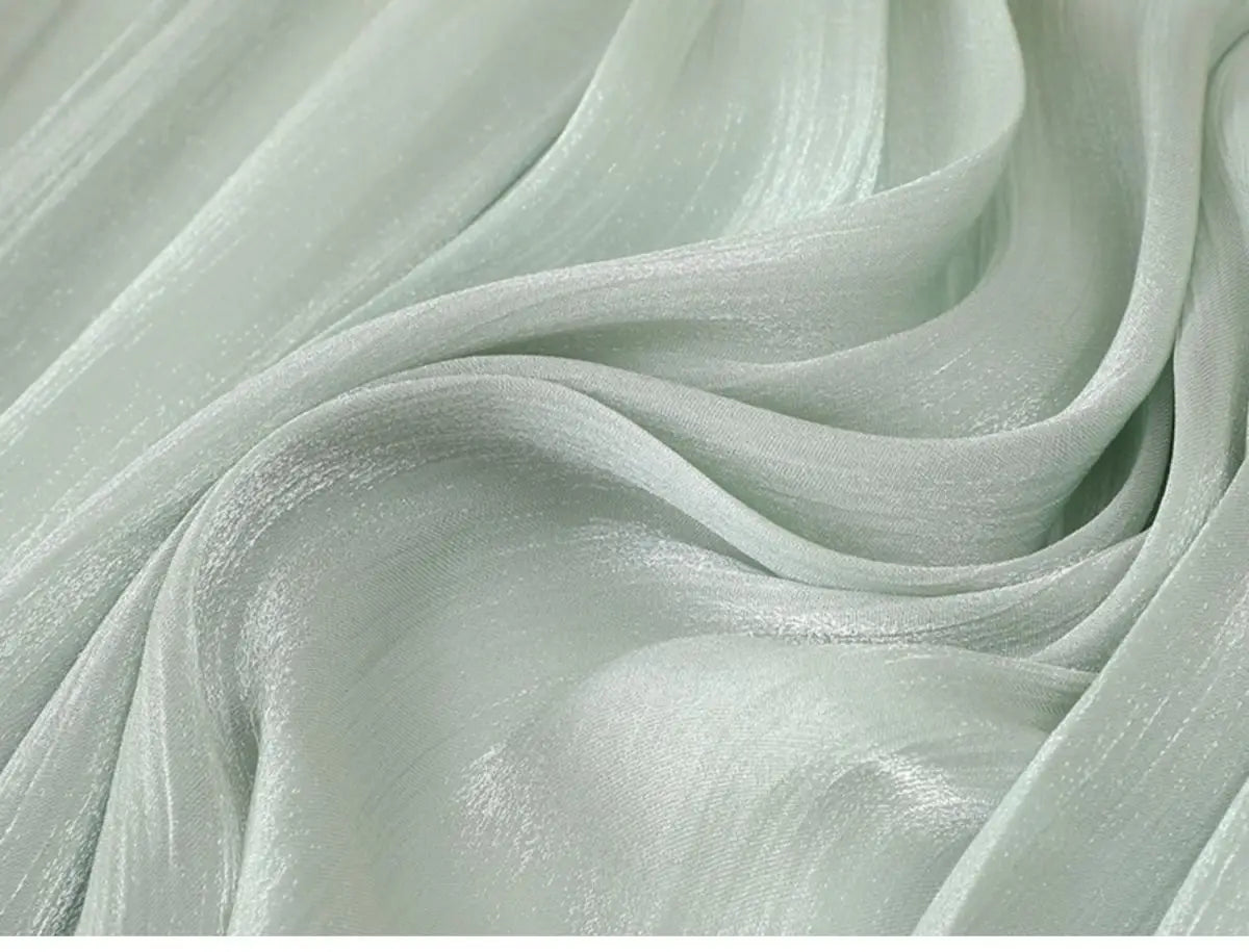 Ein zarter irrisierender Chiffon-Faltenrock aus durchsichtigem mintgrünem Gewebe mit einem dezenten Schimmer und weichen Falten.